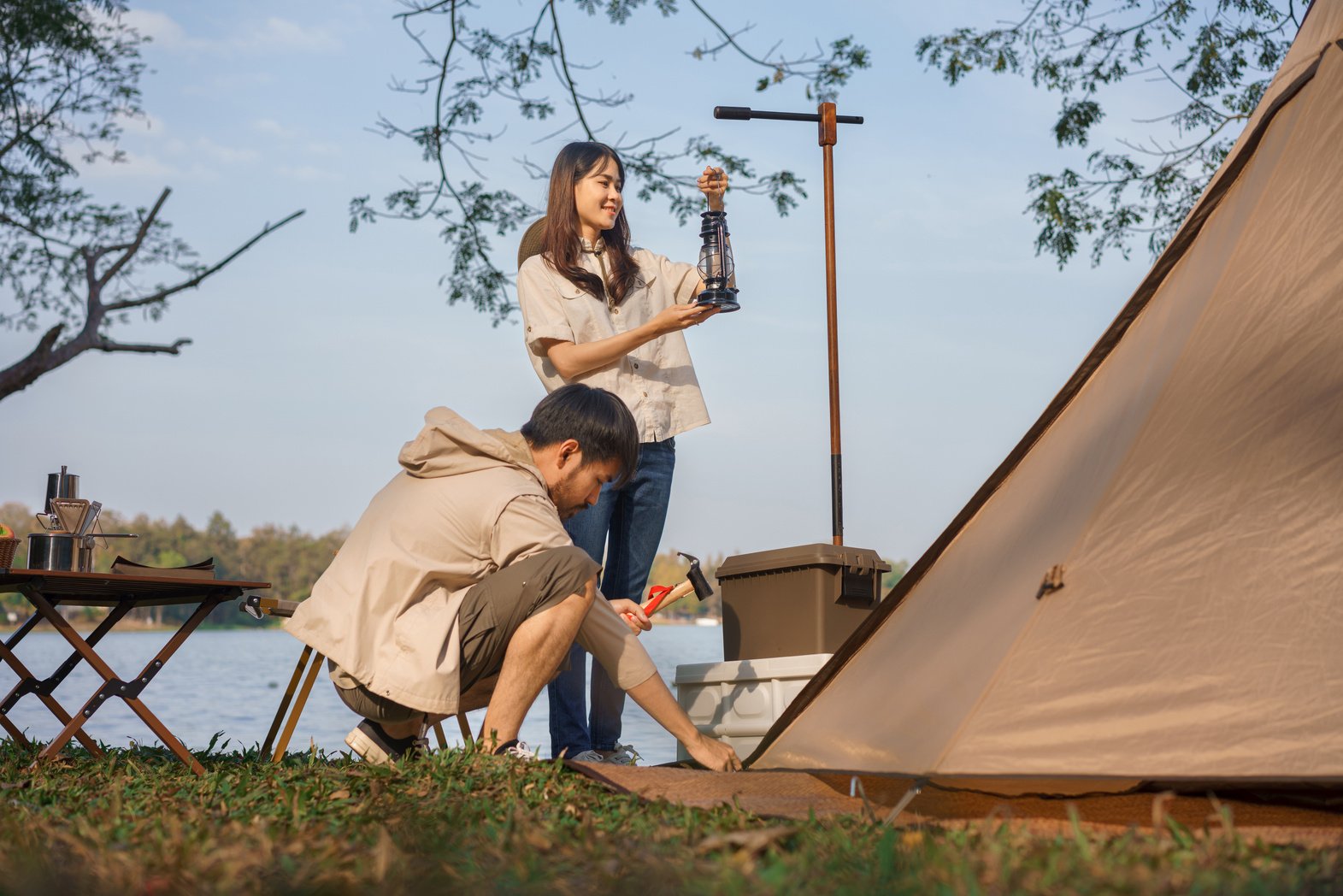 Camping concept, Young couple backpackers pitching tent and lant
